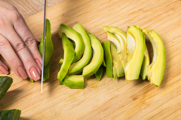 chef cuts avocado with a knife