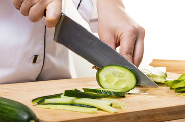 chef cuts cucumber with a knife
