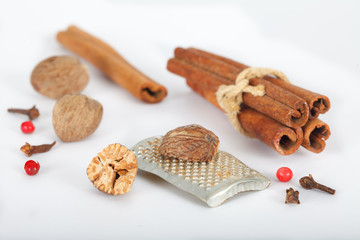 Mulled wine spice ingredients, cinnamon, cloves, red pepper and numegs on white background