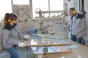 People working with slabs of marble