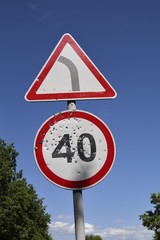 Bullet holes on the speed limit road sign. Damaged road sign.