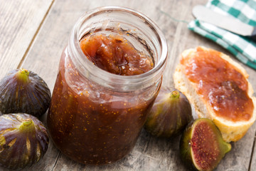 Sweet fig jam in jar on wooden table