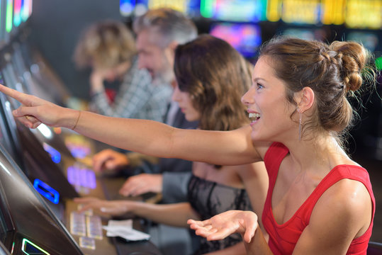 woman sitting at slot machine in casino
