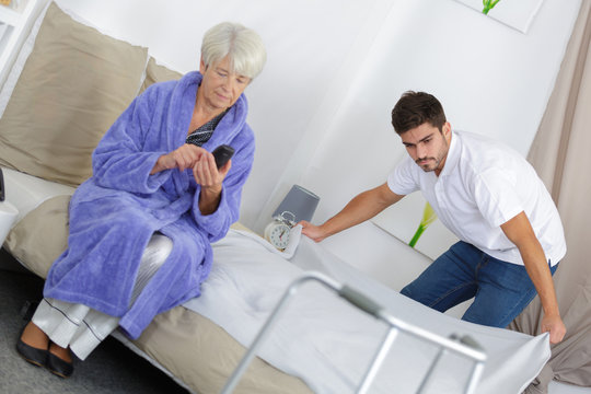 young male carer spending time with elderly woman