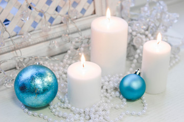 Obraz na płótnie Canvas White christmas candles and blue balls on a white wooden background