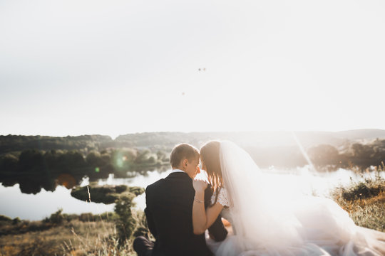 Wedding couple posing on sunset at wedding day. Bride and groom in love