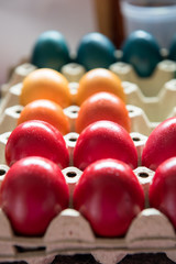 Colored eggs for Easter holliday, red, orange, yellow and blue in cardboard box