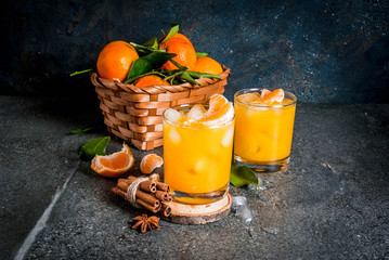 Spicy winter tangerine Cocktail with vodka, fresh tangerines, cinnamon and anise, on dark...