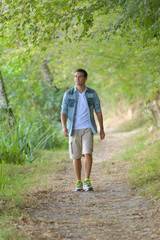 young handsome man walking in forest