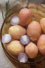 Boiled peeled potatoes and half red onion