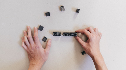 Crop man arranging printing letters