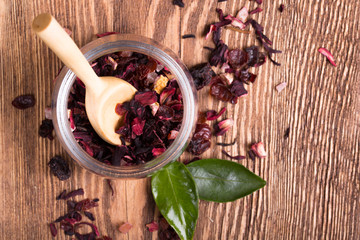 Herbal aroma fruit tea dry leaves on spoon on wooden background