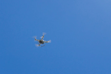 drone with the camera hovering in blue sky