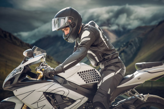 Rider on a motorcycle with Chief Mountain as the background. mountains of a cloud
