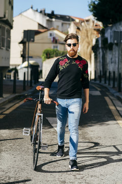 Stylish man with bicycle on street