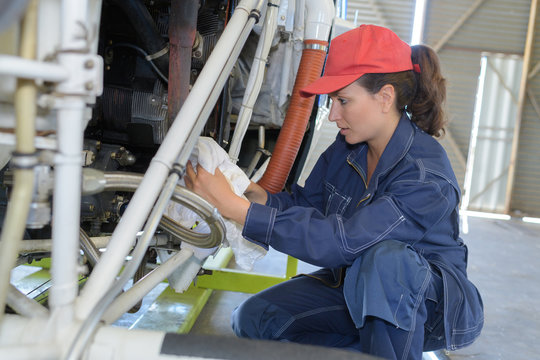 young woman mechanic working on machinery