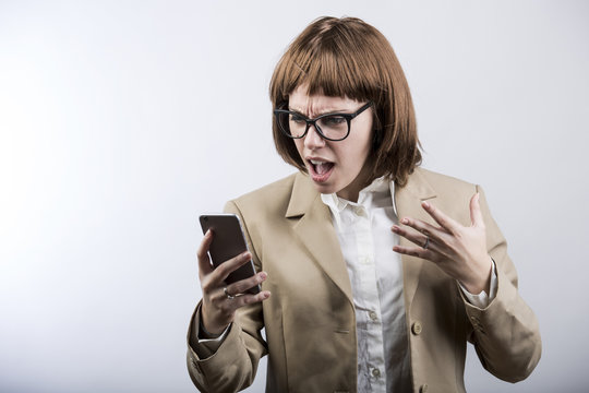 manager con i capelli a caschetto, con occhiali ,vestita con giacca e camicia,  furiosa dalla rabbia scrive un sms al cellulare cellulare  - sfondo bianco