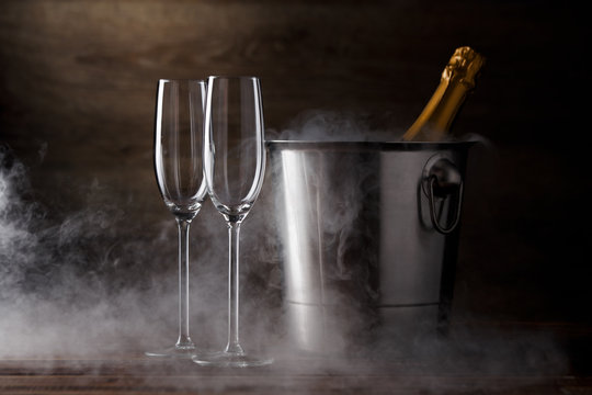 Photo of two wineglasses, iron bucket with bottle, steam