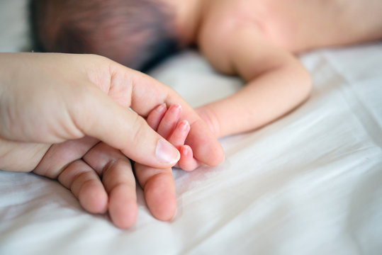 Newborn baby and mother hands
