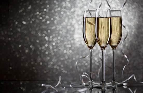 New Year's picture of three wine glasses with sparkling champagne with white ribbons