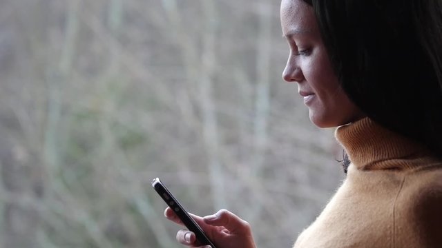 Young woman with smartphone in the forest