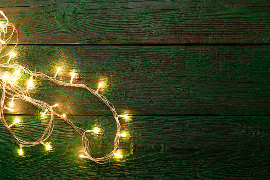 Picture of green wooden table with burning garland on side
