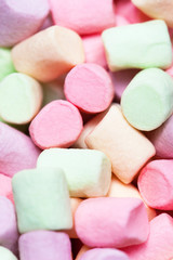 Colorful mini marshmallows background macro. Fluffy marshmallows texture and pattern. Flat lay or top view. Winter food background concept.
