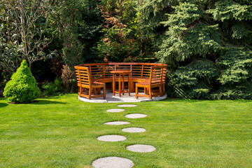 Sunny day in a spring garden with wooden table and benches
