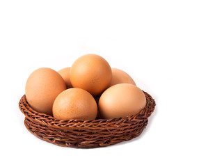 Eggs with euro coins money in basket on white.