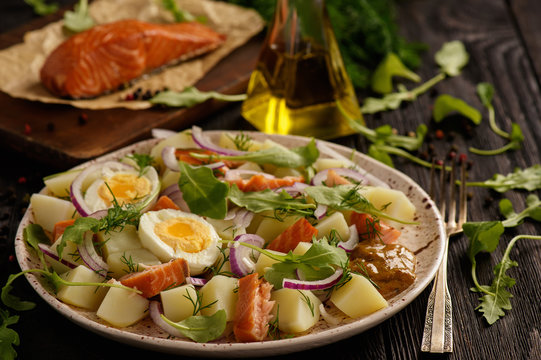 Healthy salad with salmon, potatoes, eggs and ruccola.