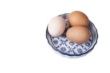 Eggs with euro coins money in basket on white.