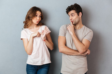 Portrait of a young attractive couple showing peace gesture