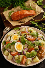 Healthy salad with salmon, potatoes, eggs and ruccola.