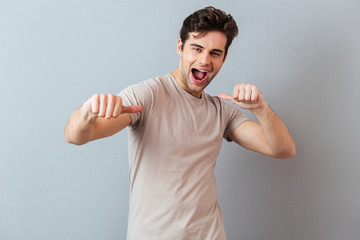 Portrait of a smiling excited man showing thumbs up gesture