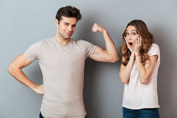 Strong young man showing biceps