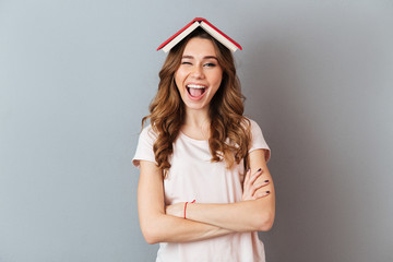 Portrait of a smiling girl holding book on her head