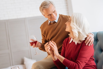 Newly engaged. Selective focus on a retired man looking at his fiancee while both enjoying a pleasant conversation and celebrating their engagement.