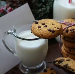 Chocolate chip cookies milk and letter for Santa on festive Xmas background