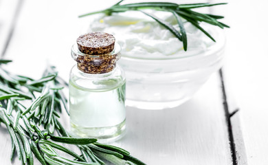 homemade cosmetics with rosemary herbs on white wooden backgroun