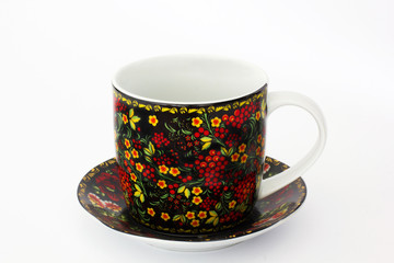 Painted cup on a plate on a white background