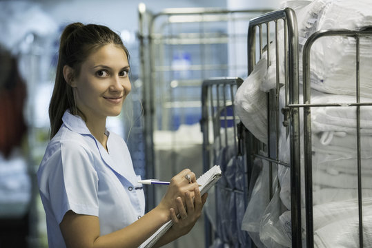 Woman checking cart of laundered bath towels
