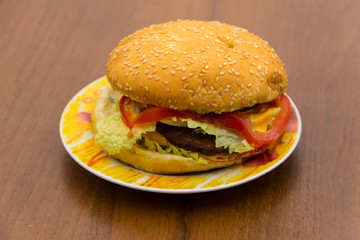 Delicious hamburger or sandwich on plate on wooden table