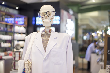 Skeleton or Skull head wearing eyeglasses and white scientific lab coat. Educational material