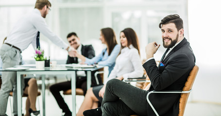 photo of the boss on the background of the handshake between the