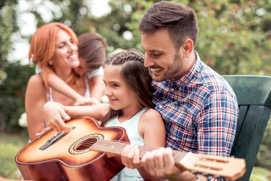 Happy family  playing guitar together