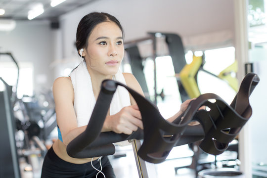 Attractive Asian Woman on exercise bikes at a gym. Woman exercise  Concept.