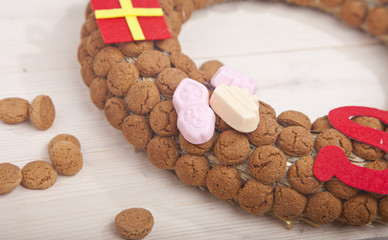 Wreath made of Dutch pepernoten on wooden background