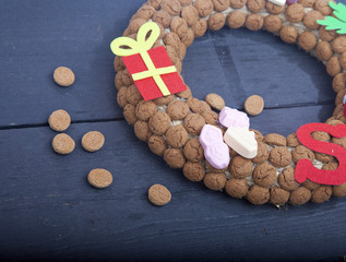Wreath made of Dutch pepernoten on wooden background