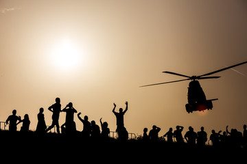 Sunset silhouettes watching an airshow - obrazy, fototapety, plakaty