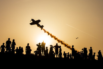 Obraz na płótnie Canvas Sunset silhouettes watching an airshow